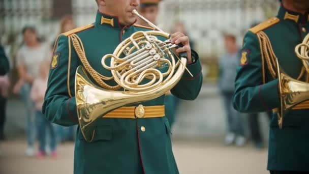 Un desfile militar de instrumentos de viento - hombres con trajes verdes tocando el cuerno francés al aire libre — Vídeos de Stock