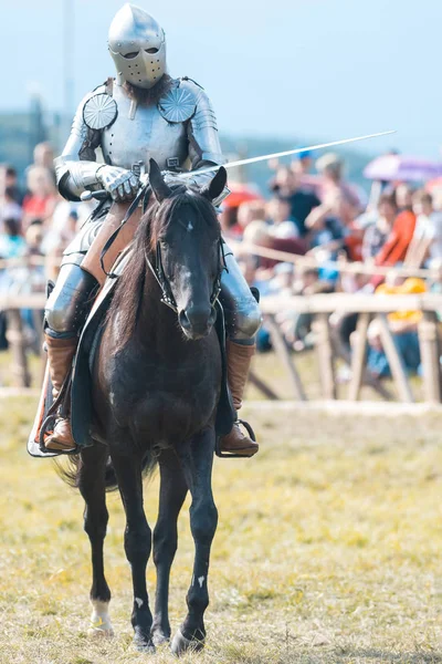 BULGAR, RUSIA 11-08-2019: Caballero montando un caballo negro en el campo de batalla sosteniendo una espada —  Fotos de Stock