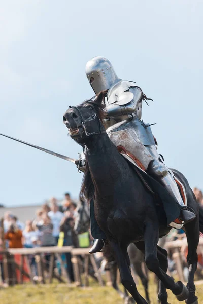 Bulgar, Rusya 11-08-2019: Şövalye elinde kılıç tutan siyah bir ata biniyor — Stok fotoğraf