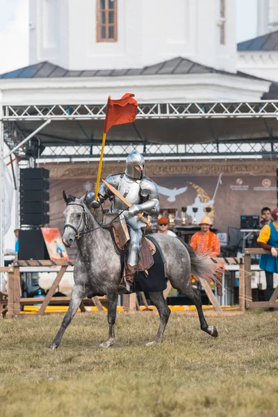BULGAR, RUSIA 11-08-2019: Caballero montando un caballo en el campo con una bandera —  Fotos de Stock