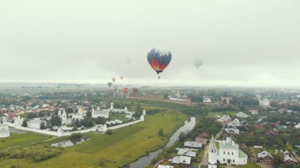 小さな村 - 空を飛ぶカラフルな気球の多く - スーズダル、ロシア — ストック動画