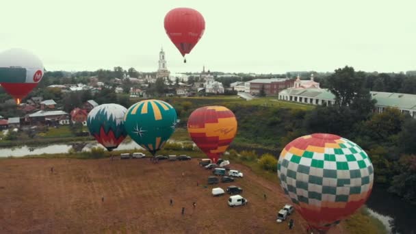 18-07-2019 Suzdal, Rusko: různé pestrobarevné vzduchové balónky létají přes vesnici-různé nápisy značek na balonách — Stock video