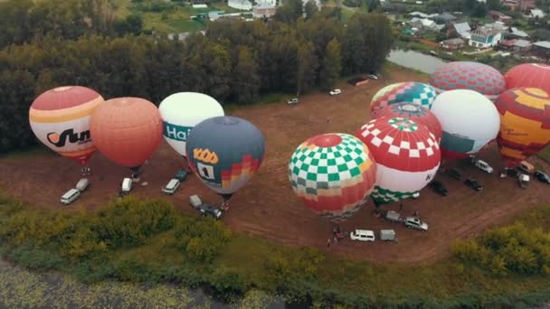 18-07-2019 Suzdal, Russia: diversi palloncini colorati stanno decollando sul campo circondati da alberi - vista dall'alto — Video Stock