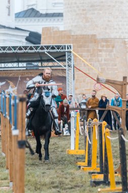 Bulgar, Rusya 11-08-2019: Şövalye yolda bir ata biniyor ve bir mızrak kullanarak çitten yüzük almak üzere - ortaçağ festivali