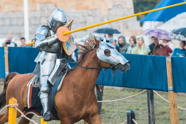 BULGAR, RUSIA 11-08-2019: Torneo de Caballero en el festival medieval - un participante en armadura completa montando un caballo marrón y apuntando al oponente —  Fotos de Stock