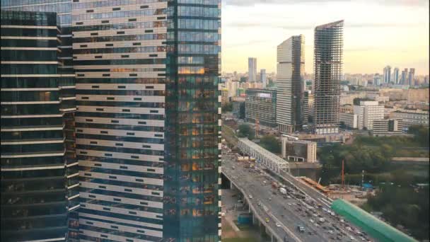 Una vista de los rascacielos en la concurrida calle: el sol se pone y las luces se encienden — Vídeo de stock