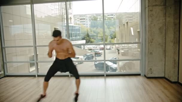 En atletisk man gör CrossFit i studion — Stockvideo