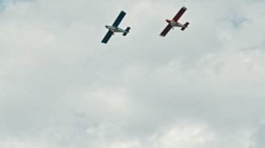 Bulutlu gökyüzünde uçan iki askeri uçak - mavi ve kırmızı uçaklar