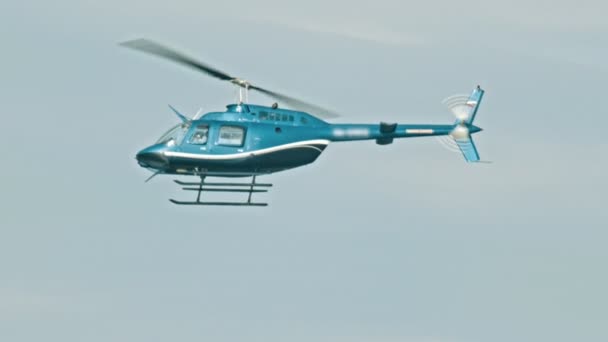 Een blauwe helikopter die in de lucht vliegt — Stockvideo