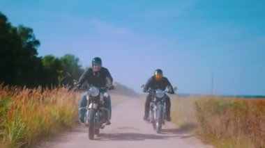 Çavdar tarlasında motosiklete binen iki erkek motosikletçi