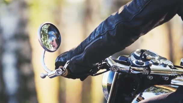Brutalny człowiek motocyklista siedzi na motocyklu i zaczyna jeździć — Wideo stockowe