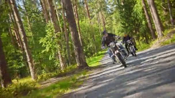 Twee brutale mannen motorrijders in helm rijden een motorfiets in het bos-een camera na de bewegingen van fietsers — Stockvideo