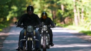 Ormanda bir motosiklet sürme iki acımasız yetişkin erkek motosiklet - parlak bir gün