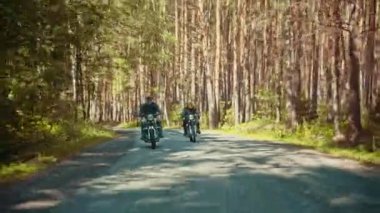 Ormanda bir motosiklet sürme iki acımasız erkek motosiklet - parlak güneşli bir gün