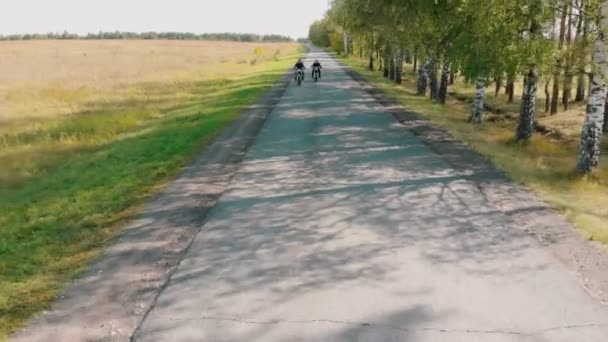 Dua orang pengendara sepeda motor berkuda oleh hutan birch pada kecepatan tinggi — Stok Video