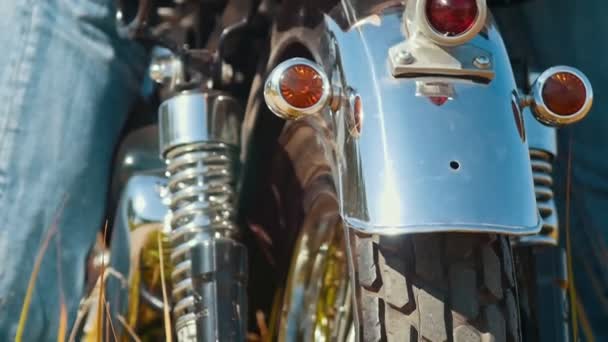 Чистый блестящий мотоцикл на дороге, окруженный ржаным полем - задняя шина — стоковое видео