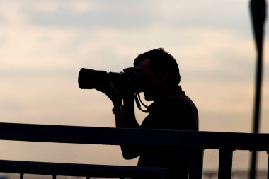 Erken günbatımı bir arka plan üzerinde Fotoğrafçı siluet