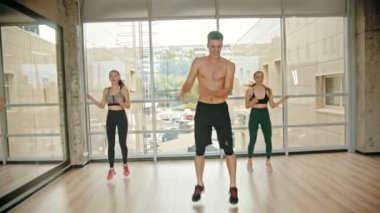 Stüdyoda Fitness eğitimi - iki genç kadın antrenörü ile eğitim - yerinde atlama - dayanıklılık egzersizleri