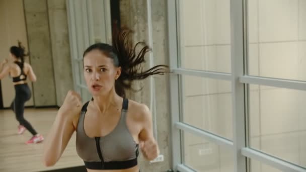 Une femme sportive boxe et saute sur place - entraînement d'endurance intense — Video