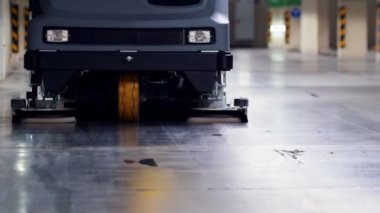 Bir asfalt çamaşır makinesi yeraltı otoparkında sürmek - yerden kir uzak fırçalama