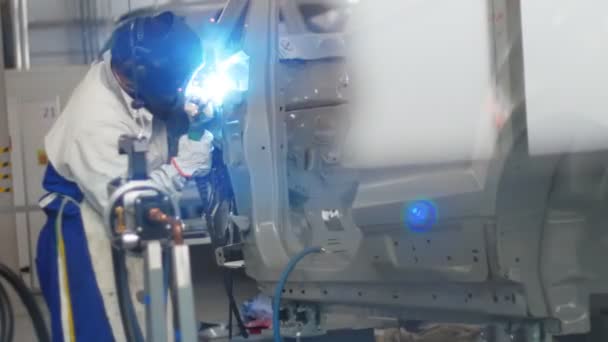 A man in a protective suit is engaged in welding items — Stock Video