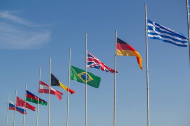 Gökyüzünün arka planında rüzgarda esen dünya ülkelerinin bayrakları