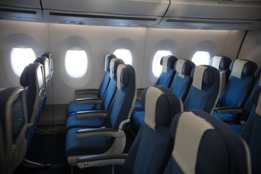 Uçağın bir ekonomi sınıfı boş temiz kabin - boş lacivert sandalye - portholes açıldı