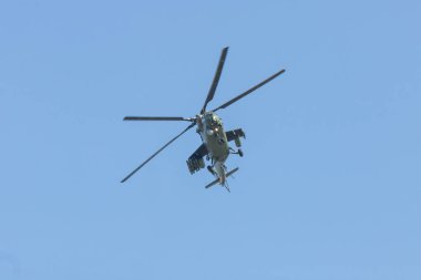 Mavi gökyüzünde uçan bir askeri helikopter