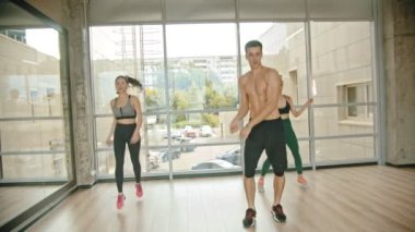 Stüdyoda Fitness eğitimi - iki genç kadın antrenörü ile eğitim - yerinde atlama