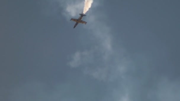 Ένα μπλε και κίτρινο αντιδραστικό αεροπλάνο που πετάει στον ουρανό και εκτελεί μια παράσταση με την απελευθέρωση του καπνού — Αρχείο Βίντεο