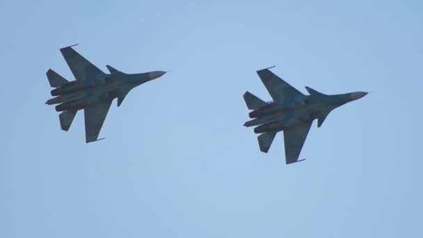 Dos aviones de combate militares de camuflaje verde volando en círculos en el cielo — Vídeos de Stock