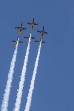 Mavi ve sarı reaktif uçaklar gökyüzünde uçan ve bir gösteri performans