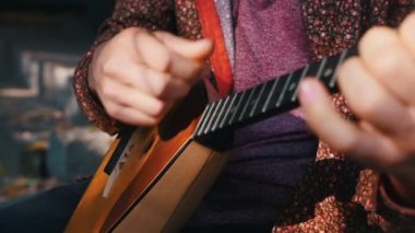 Açık havada balalaika oynayan bir adam