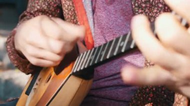 Balalaika açık havada oynayan sakallı bir adam - kır evinin yanında duruyor