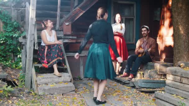 Una mujer bonita bailando junto a la música - un hombre tocando balalaika — Vídeos de Stock