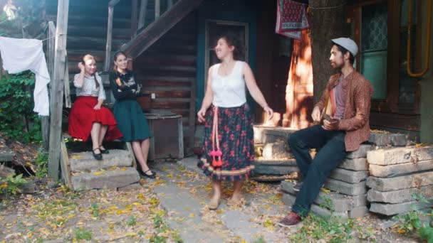 En kvinna i färgglada kjol dansar med musik-en man som spelar Balalaika — Stockvideo