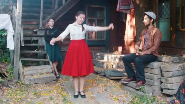 Žena v červených sukních tančící u hudby-muž hrající balalajka-další žena tleskala — Stock video