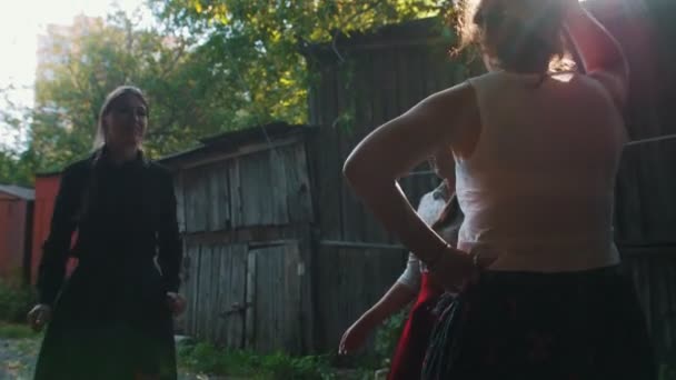 Frauen in bunten Kleidern tanzen zur Musik und haben Spaß - ein Mann spielt Balalaika - die Sonne geht unter — Stockvideo