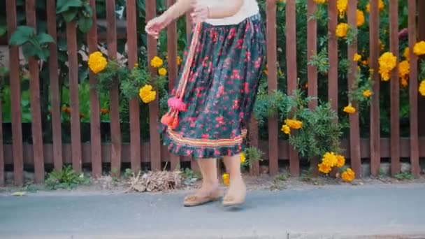 Una mujer en falda larga bailando en la calle por la valla piernas — Vídeos de Stock