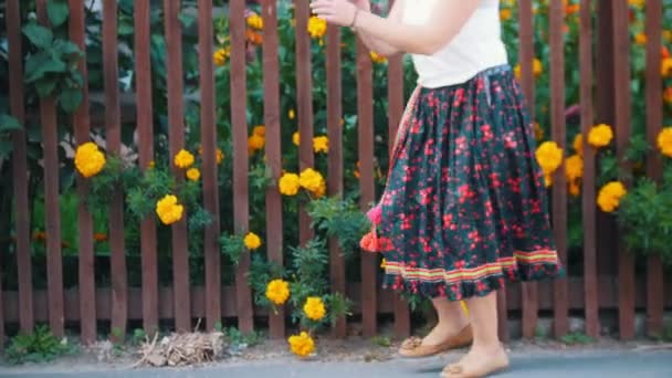 Een vrouw in lange rok dansen door het hek op de straat — Stockvideo