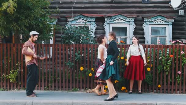 Uzun etekli genç kadınlar müzik eşliğinde köyde sokakta halk dansları dans — Stok video