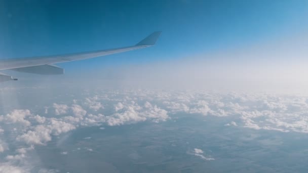 Reisekonzept. Blick aus dem Flugzeugfenster auf den blauen Himmel und die Wolken — Stockvideo