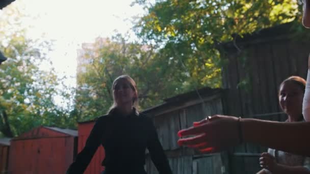 Ženy stojící poblíž venkovského domu-tančí a baví se-muž hrající balaljku-jasné sluneční světlo — Stock video