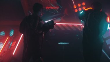 İki adam büyük bir nakliye makinesi önünde duran ve bir lazer silah ateş