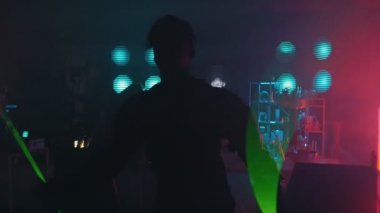 Laboratuvarın arka planında lazer gösterisi yapan bir adam.