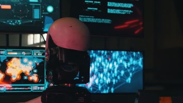 Robô humanoide futurista sentado ao lado dos monitores e trabalhando - uma cabeça gira ao redor — Vídeo de Stock