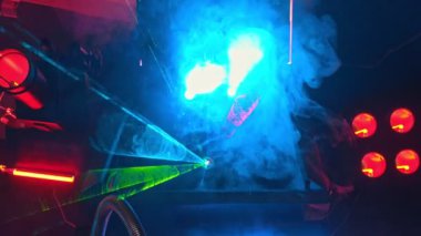 Duman ve neon ışıkları ile kaplı büyük bir teknolojik askeri makine - lazer gösterisi