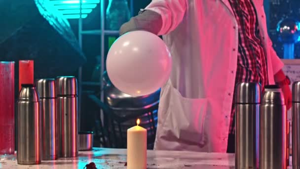 Een man verlicht een ballon met gas erin en het krijgen van een explosie — Stockvideo