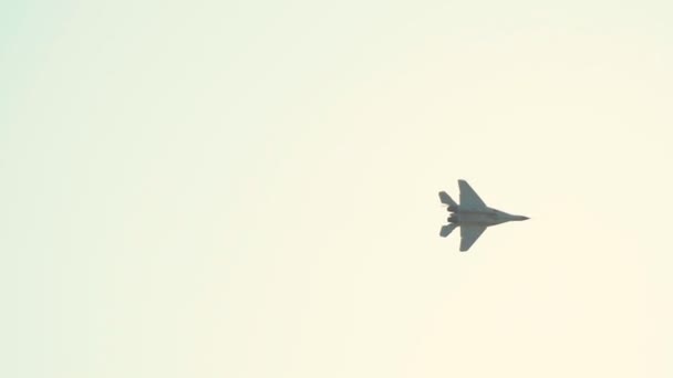Реактивный самолет, летящий в небе и выполняющий шоу - теряющийся в белом ярком небе — стоковое видео