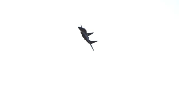 Военный реактивный самолет, летящий в белом ясном небе и выполняющий шоу — стоковое видео